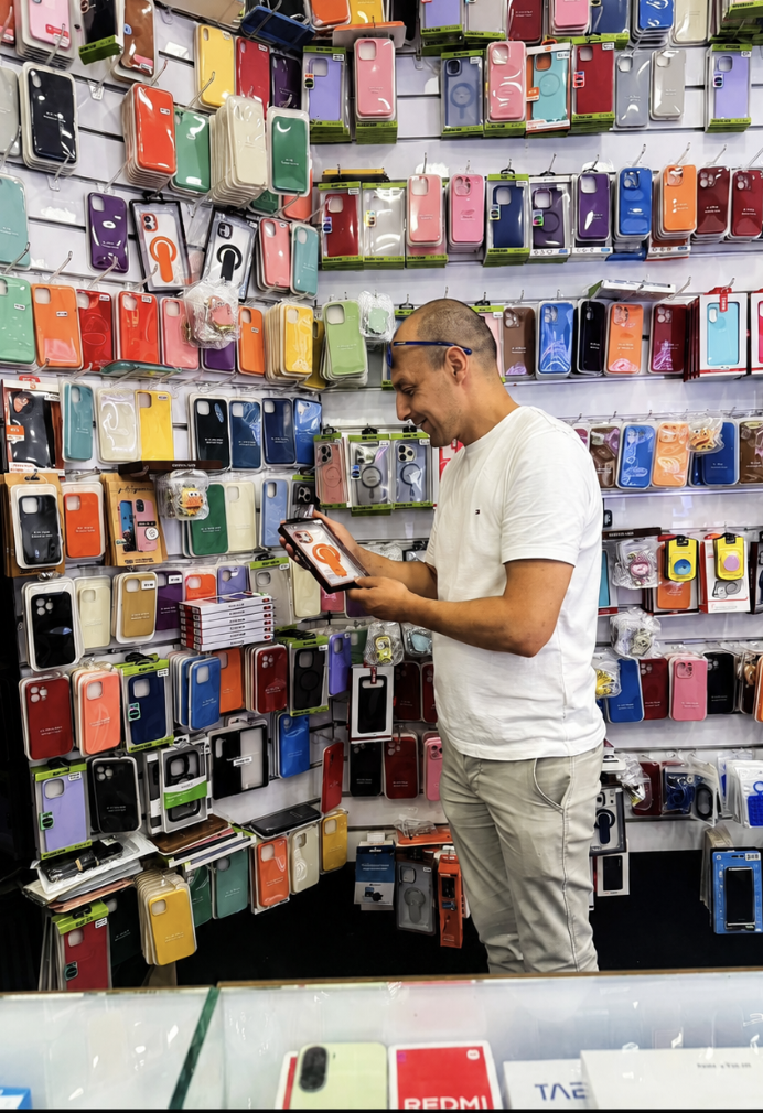 Conseiller TELLIE 1 choisissant une coque devant le mur d'accessoires